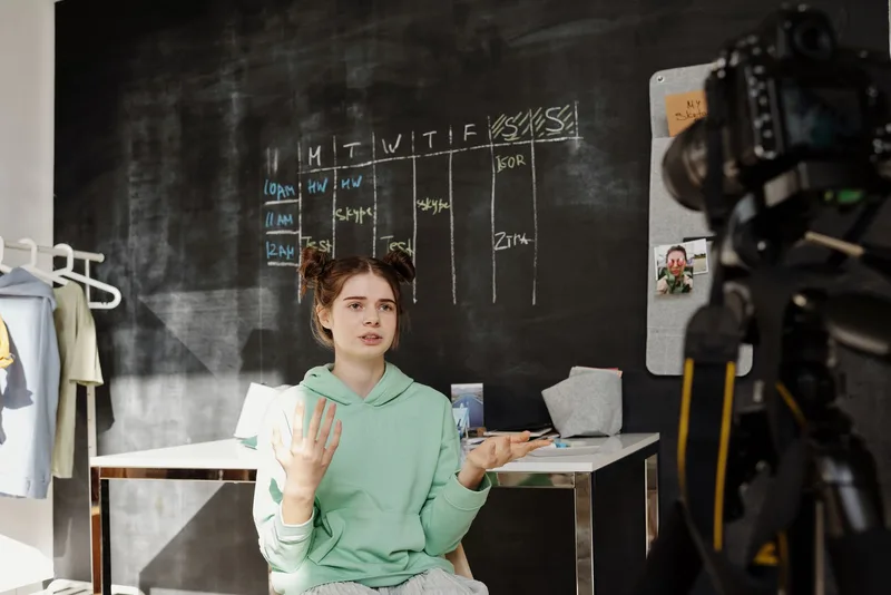 A creator filming a video in front of a camera, representing different content niches and their posting schedules