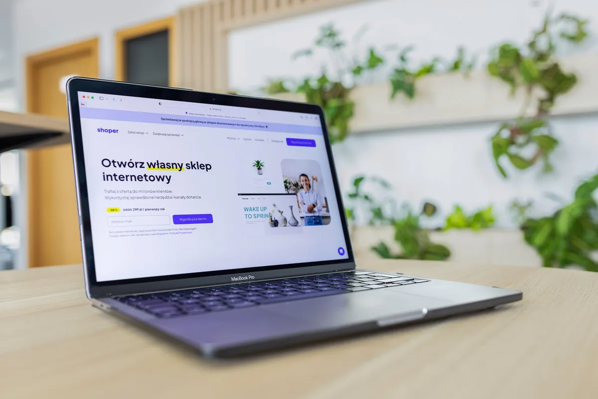 Creator using a laptop in a bright modern workspace to review email growth analytics