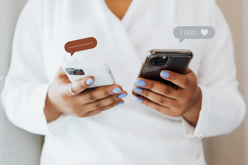 Two creators laughing while reviewing TikTok comment engagement on a smartphone together