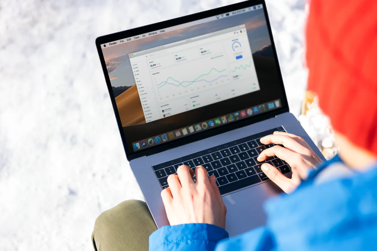 Person reviewing analytics on a laptop outdoors, representing a creator tracking Twitter growth metrics