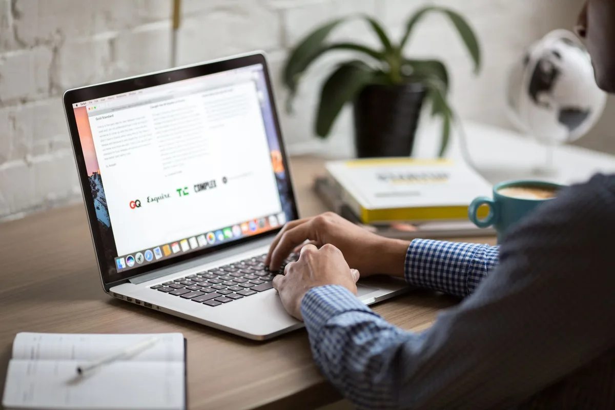 Creator writing a newsletter on a laptop at a clean minimal desk
