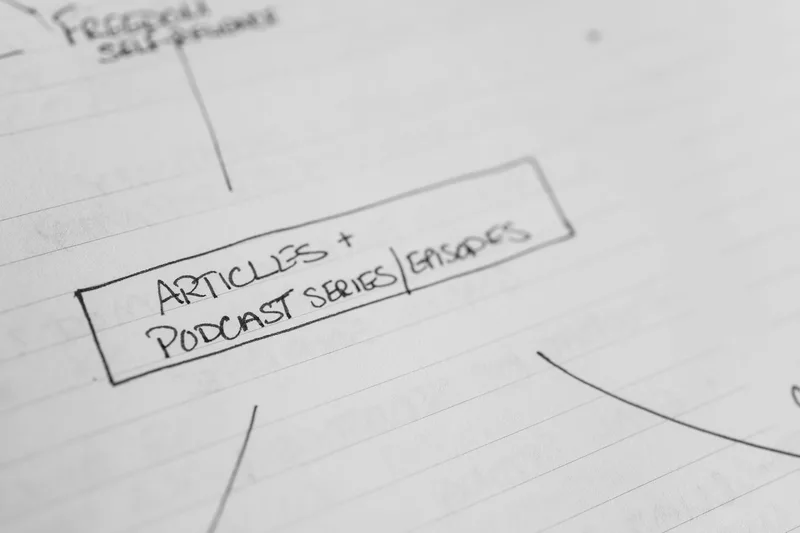 Simple newsletter structure layout showing four core sections on paper beside a laptop