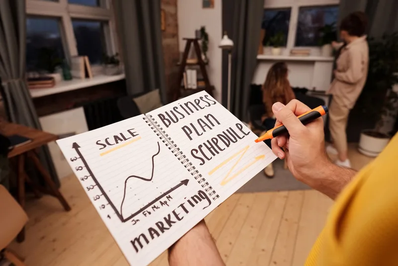 Creator holding a notebook and pen, planning a content collab schedule and tracking strategy