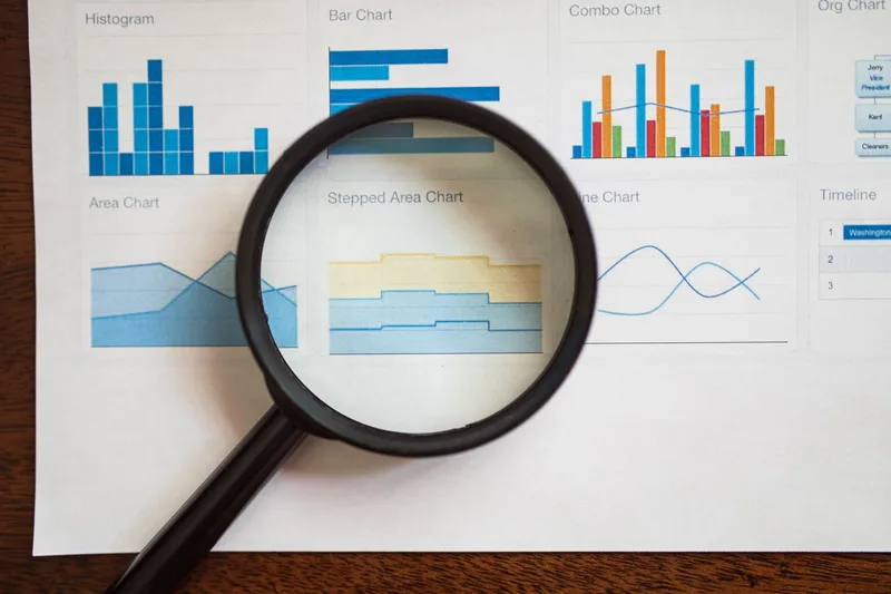 Business professional reviewing social media analytics data on a tablet, analyzing collab post reach and engagement metrics