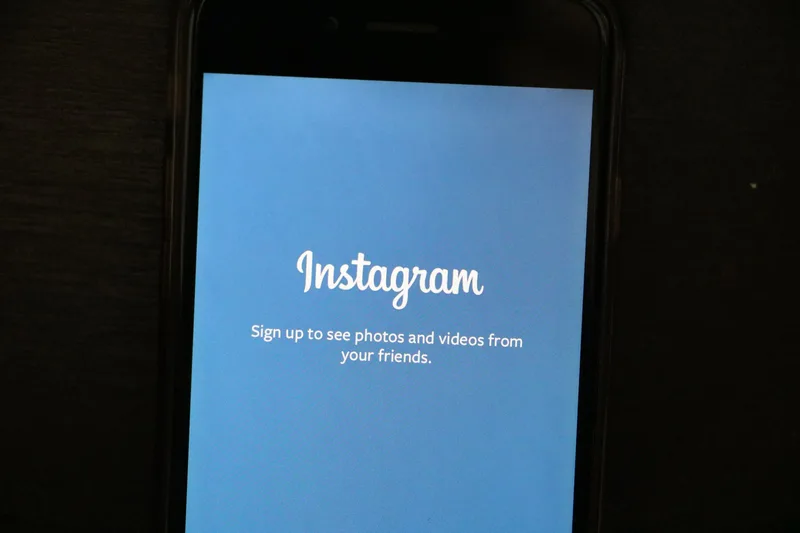 Smartphone displaying the Instagram app, representing the collab invite flow during post creation