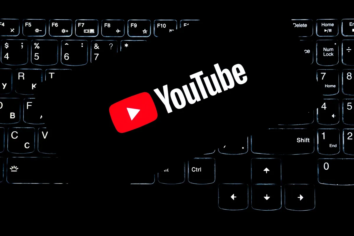 YouTube logo on a backlit keyboard representing content creation and thumbnail design